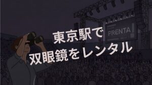 夜のライブコンサート会場で、双眼鏡を覗く女性。中央に大きく「東京駅で双眼鏡をレンタル」とあり、奥のスクリーンには「PRENTA」の文字。満員の観客がいる。
